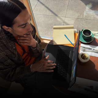 Pessoa a trabalhar num café com um MacBook Pro que não está ligado à tomada