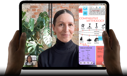 Vista frontal do iPad Pro, preto sideral, colocado na horizontal, ecrã com moldura preta e cantos arredondados, mãos a segurar os lados esquerdo e direito, ecrã apresenta uma conversa no FaceTime com tradução em tempo real e uma app educativa com uma apresentação intitulada