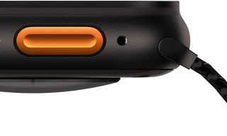 Vista lateral esquerda do Apple Watch Ultra 3 com caixa em titânio preto, sensor convexo atrás, altifalante/ventilação, botão Ação e microfone